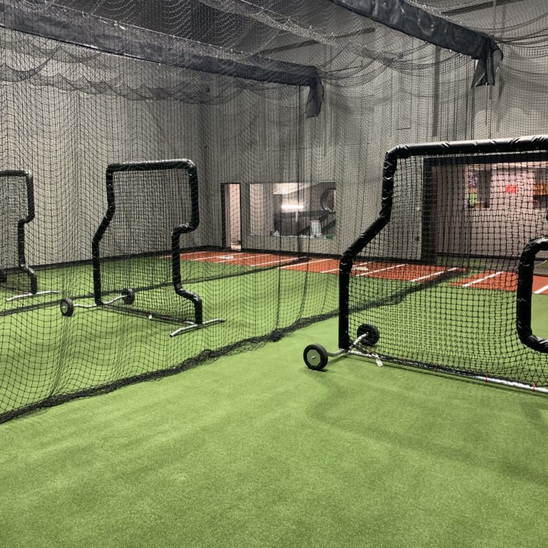 Big baseball training room with individual lanes and nets for batting practice